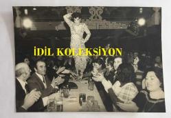 FERİ CANSEL'İN ORİJİNAL 2'Lİ FOTOĞRAF SETİ - 15 x 11 cm ve 14 x 10 cm EBADINDA - FERİ CANSEL ALMANYA'DA SAHNE ALDIĞI BİR MEKANDA MASALARIN ÜZERİNE ÇIKIP DANS EDERKEN ÇEKİLMİŞ 2 FARKLI KARE, 17 OCAK 1978