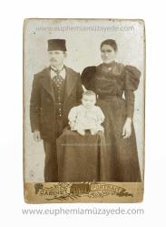 [Kabin Fotoğraf] Fesli Osmanlı tip / beyefendi ve şık elbiseli ve broşlu hanımefendiden oluşan, muhtemelen gayrimüslim aile stüdyo hatırası