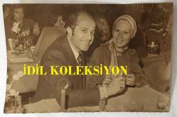 KANTO EFSANESİ NURHAN DAMCIOĞLU'NUN ORİJİNAL FOTOĞRAFI - 18 x 12 cm EBADINDA - NURHAN DAMCIOĞLU ve EŞİ ERCAN YENSENİ BİR MEKANDA AYNI MASADA GÜLÜMSEYEREK POZ VERİRKEN ÇEKİLMİŞ BİR HATIRA FOTOĞRAFI