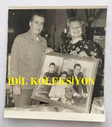 TÜRK SANAT MÜZİĞİ YORUMCUSU ve OYUNCU PERİHAN ALTINDAĞ SÖZERİ'NİN ORİJİNAL FOTOĞRAFI  - 12 x 10 cm EBADINDA - PERİHAN ALTINDAĞ SÖZERİ, EŞİ EMİN SÖZERİ İLE BİRLİKTE ESKİ FOTOĞRAFLARINI GÖSTERİP POZ VERİRKEN ÇEKİLMİŞ BİR HATIRA FOTOĞRAFI