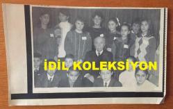 VEHBİ KOÇ'UN AJANS BASIMI FOTOĞRAFI (KAĞIT BASKI) - 18 x 11 cm EBADINDA - VEHBİ KOÇ, BİR ETKİNLİKTE KADINLARLA ve ÇOCUKLARLA HATIRA POZU VERİRKEN, 1987