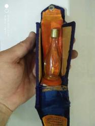 Eski yazı etiketli parfüm şişesi. Kadife eski kutuda yarı dolu metal kapaklı.