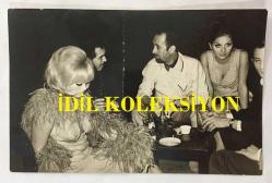 BESTECİ ve ARANJÖR FECRİ EBCİOĞLU'NUN ORİJİNAL FOTOĞRAFI - 18 x 12 cm EBADINDA - FECRİ EBCİOĞLU, GÜLSÜM KAMU, GÖNÜL YAZAR ve HALDUN DORMEN 1960'LARDA BİR KEMANDA OTURUP SOHBET EDERLERKEN ÇEKİLMİŞ BİR KARE