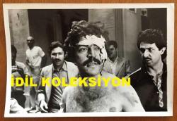 HAYATİ HAMZAOĞLU'NUN ORİJİNAL FOTOĞRAFI  - 18 x 12 cm EBADINDA - HAYATİ HAMZAOĞLU BİR YEŞİLÇAM FİLMİNDE BAŞI SARGILIYKEN ÇEKİLMİŞ BİR KARE