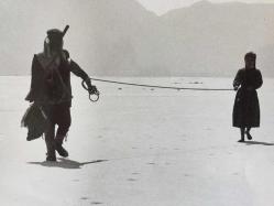 HAYATİ HAMZAOĞLU'NUN ORİJİNAL BÜYÜK BOY FOTOĞRAFI  - 24 x 18 cm EBADINDA - HAYATİ HAMZAOĞLU BİR YEŞİLÇAM FİLMİ SAHNESİNDE ARAZİDE BİR KIZI İPLE YÜRÜTÜRKEN ÇEKİLMİŞ BİR KARE