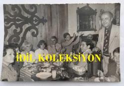 TEKİN AKMANSOY'UN ORİJİNAL FOTOĞRAFI - 18 x  12 cm EBADINDA - TEKİN AKMANSOY, EŞİ MERAL AKMANSOY, KIZLARI ARZU AKMANSOY, HURİYE MERSUK, SOLMAZ ÖZKAN, NEŞE DURU,  BETİL DURU ve ALİ MERSUK BİR MEKANDA TOPLUCA YEMEK YERKEN ÇEKİLMİŞ BİR HATIRA FOTOĞRAFI