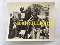 TEKİN AKMANSOY'UN ORİJİNAL 2'Lİ FOTOĞRAF SETİ - 15 x  12 cm EBADINDA - TEKİN AKMANSOY, NURİ KANTAR ROLÜYLE HALKIN ARASINDA KONUŞMA YAPIP OMUZLARDA TAŞINIRKEN ÇEKİLMİŞ 2 FARKLI KARE