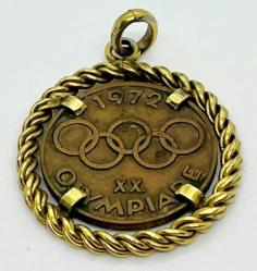 Almanya, Münih 1972 Yaz Olimpiyatları/XX Münih Olimpiyatları ve Şehir Simgeleri Temalı Hatıra Madalyon. Özel Tasarımlı Olarak Kolye Haline Getirilmiştir. Ön Yüzünde; Olimpiyat Oyunları Halkaları ve Münih Yazısı İle Tarih Yer Alır. Arka Yüzünde; Frauen Kirche/Kadınlar Kilisesi ve Münih'in En Eski Kilisesi Aziz Petrus Kilisesi Yer Almaktadır. 1972. Madalyon Kısmı; Bronz. Burmalı Kolye Çerçeve Kısmı; 