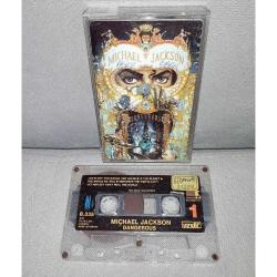 Kaset Michael Jackson Dangerous albümü. orijinal 1991 Uzelli Kağıt Baskı. Kasette çalışmasını etkilemeyen ufak kırık ile kartonet ve kasette yazı var.