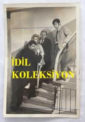 TÜRK SANAT MÜZİĞİ SANATÇISI SEVİM TUNA'NIN ORİJİNAL 2'Lİ FOTOĞRAF SETİ - 18 x 12 cm  EBADINDA - SEVİM TUNA YANINDAKİLERİN YARDIMIYLA KOLTUK DEĞNEKLERİYLE YÜRÜRKEN ÇEKİLMİŞ 2 FARKLI KARE