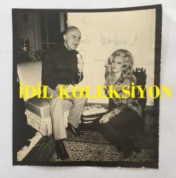 TÜRK SANAT MÜZİĞİ SANATÇISI SEVİM TUNA'NIN AJANS BASIMI FOTOĞRAFI (KAĞIT BASKI) - 12 x 12 cm  EBADINDA - SEVİM TUNA ve GAZETECİ NEDRET SELÇUKER SOHBET EDERKEN ÇEKİLMİŞ BİR KARE