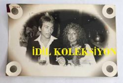 TÜRK SANAT MÜZİĞİ SANATÇISI SEVİM TUNA'NIN KIZI CANAN'IN EVLENDİĞİ GENÇLE ÇEKİLMİŞ ORİJİNAL BİR FOTOĞRAFI ve TAM AJANS'IN BU KONUDA YAZILMIŞ ORİJİNAL HABER METNİ, 2'Lİ SET - FOTOĞRAF 18 x 12 cm, HABER METNİ 29 x 17 cm  EBADINDA -SEVİM TUNA: ''KIZIM DOĞUM YAPTIKTAN SONRA DÜNYANIN EN GÜZEL BÜYÜKANNESİ ÜNVANINI LİZ'DEN ALACAĞIM'' DEDİ