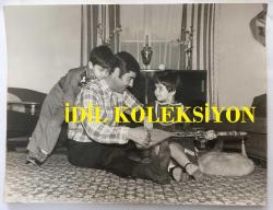 NURİ SESİGÜZEL'İN BÜYÜK BOY ORİJİNAL FOTOĞRAF  - 24 x 18 cm EBADINDA  - NURİ SESİGÜZEL EVİNDE KENDİSİNE SARILAN OĞLU MEHMET ve CURA SAZ ÇALMAYI ÖĞRETTİĞİ KIZI BİRGİ İLE ZAMAN GEÇİRİRKEN ÇEKİLMİŞ NET KALİTEDE GÜZEL BİR HATIRA FOTOĞRAFI... ÖZEL ARŞİV.