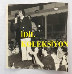 NURİ SESİGÜZEL'İN ORİJİNAL 2'Lİ FOTOĞRAF SETİ - 16 x 14 cm EBADINDA  - NURİ SESİGÜZEL BİR MEKANDA MÜŞTERİLERİN MASASINA GELİP ŞARKI OKURKEN ÇEKİLMİŞ 2 FARKLI FOTOĞRAF