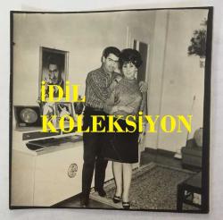 NURİ SESİGÜZEL'İN ORİJİNAL FOTOĞRAFI - 11 x 11 cm EBADINDA  - NURİ SESİGÜZEL EŞİ AYSEL SESİGÜZEL'LE EVLERİNDE HATIRA POZU VERİRLERKEN ÇEKİLMİŞ BİR FOTOĞRAF (MEHMET BULUT)