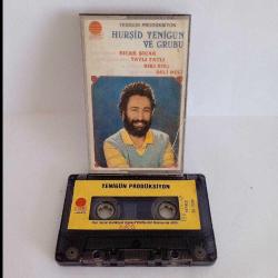 Kaset Hurşid Yenigün ve grubu sıcak sıcak tatlı tatlı sıkı sıkı deli deli. Orijinal kağıt baskı. Kasette yazı ile B4 şarkısında 15 saniye kayıp var.