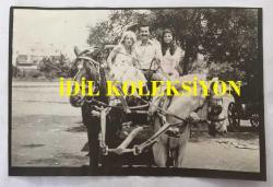 TÜRK HALK MÜZİĞİ SANATÇISI ŞAKİR ÖNER GÜNHAN'IN ORİJİNAL AJANS-BASIN FOTOĞRAFI (KAĞIT BASKI) - 18 x 12 cm EBADINDA  - ŞAKİR ÖNER GÜNHAN ve TEKGÜL GÖZALAN, FAYTONA BİNİP ATLARLA POZ VERİRKEN ÇEKİLMİŞ BİR KARE