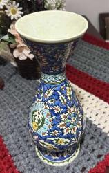 Kütahya El Yapımı Çini Vazo Boyut: 36 cm Dönem: 20. yüzyıl sonları Menşei: Kütahya, Türkiye Teknik: El tornasında şekilllendirilmiş, fırçayla el ile desenlenmiş, şeffaf sır ile kaplanmış Motifler: Klasik Osmanlı çini sanatından esinlenen lale, karanfil ve stilize yaprak desenleri, Mavi, beyaz, sarı ve yeşil tonlarında zengin çini boyanası Kullanım: Dekoratif amaçlıdır; otantik çini sanatını yansıtan koleksiyonluk bir parçadır Durumu: Kusursuz, herhangi bir çatlak ya da deformasyon bulunmamaktadır