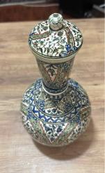 ESKİ DEKORLUK KÜTAHYA ÇİNİ ŞİŞE SÜRAHİ Dışa dönük düz ağızlı, pedestal ayaklı, küresel gövdeli ve kapaklı şişenin yüzeyi kobalt mavi, yeşil, sarı, kiremit kırmızısı ve turkuaz ile hayati, şakayık, sümbül, mine ve rozet çiçekleri ile dekorlu.  Dönem: 20. yüzyıl sonları Yükseklik 34 cm