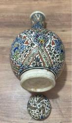 ESKİ DEKORLUK KÜTAHYA ÇİNİ ŞİŞE SÜRAHİ Dışa dönük düz ağızlı, pedestal ayaklı, küresel gövdeli ve kapaklı şişenin yüzeyi kobalt mavi, yeşil, sarı, kiremit kırmızısı ve turkuaz ile hayati, şakayık, sümbül, mine ve rozet çiçekleri ile dekorlu.  Dönem: 20. yüzyıl sonları Yükseklik 34 cm