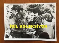 KIBRIS BARIŞ HAREKATI'NIN ORİJİNAL AJANS-BASIN FOTOĞRAFI  - 18 x 13 cm EBADINDA - KIBRIS BARIŞ HAREKATI SONRASINDA GÜNEY'DEKİ TÜRKLERİN GÖÇ ETMEYE BAŞLADIKLARI SÜREÇTE GEÇİT TÖRENİNDEN BİR KARE, TÖREN SIRASINDA BİR TÜRK SUBAYI RADYOYA DEMEÇ VERİRKEN, 1975