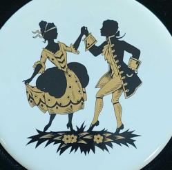 İngiltere, Orijinal Staffordshire Seramikleri/ Koleksiyonluk Özel Yapım Seramik Yuvarlak Karo Plakada Viktorya Dönemi Genç Bir Çiftin Dans Ettiği Sahne Tasvir Edilmiştir. Beyaz Karo Madalyonun Üzerinde Bir Erkek-Bir Kadın Figürü Var. Siyah ve Altın Renklidir. Çerçevenin İçinde Siyah Kadife Üzerine Yerleştirilmiştir. Çerçeve Kare Boyutunda ve Ahşap Kenarları Metalik Altın Tonludur. 18 cm/Orijinal İngiltere El Yapımı ve Sertifikalıdır. (1971)