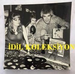 ŞARKICI GENÇ OSMAN YAVAŞ'IN ORİJİNAL FOTOĞRAFI - 11 x 11 cm EBADINDA - GENÇ OSMAN YAVAŞ, EVİNDE EŞİ ve KIZIYLA BİRŞİKTE PLAKLARINI GÖSTERİRKEN ÇEKİLMİŞ BİR KARE