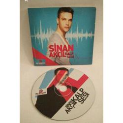 Cd Sinan Akçıl Kalp Sesi albümü. Orijinal. Sorunsuz çalışıyor.    1. B'işey Olmuş Feat: İzel 2. Cumartesi Dance Mix Feat: Ajda Pekkan 3. Atma Feat: Hande Yener 4. Bana Uyan Feat: Ziynet Sali 5. Şampiyon Feat: Teodora 6. Söndürülmez İstanbul Feat: Hande Yener 7. Bişey Olmuş (E.K. Remix) 8. Atma (Yalçın Aşan Remix) 9. Cumartesi (Club Mix) Feat: Ajda Pekkan 10. Şampiyon (Solo) 11. Atma S.Ç. Remix 12. Cumartesi (Dance Mix) 13. Cumartesi (Club Mix) 14. Bana Uyan (R&B Versiyon) Feat: Elif Kaya