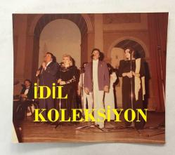 KLASİK TÜRK MÜZİĞİ SANATÇISI ve BESTECİ YILDIRIM GÜRSES'İN ORİJİNAL FOTOĞRAFI - 10 x 8 cm EBADINDA - YILDIRIM GÜRSES ALMANYA TURNESİNDE EŞİ AYLA GÜRSES ve VEDAT ÇETİNKAYA'YLA SAHNEDEYKEN ÇEKİLMİŞ BİR FOTOĞRAF, 2 NİSAN 1986