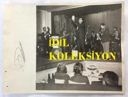KLASİK TÜRK MÜZİĞİ SANATÇISI ve BESTECİ YILDIRIM GÜRSES'İN ORİJİNAL BÜYÜK BOY FOTOĞRAFI - 24 x 18 cm EBADINDA - YILDIRIM GÜRSES 1960'LARDA SAHNEDE ORKESTRANIN ÖNÜNDE ŞARKI OKURKEN ÇEKİLMİŞ BİR FOTOĞRAF
