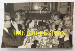 TÜRK SANAT MÜZİĞİ SANATÇISI SEÇİL HEPER'İN ORİJİNAL FOTOĞRAFI - 18 x 12 cm  EBADINDA - SEÇİL HEPER KULÜP SAHİBİ OLAN ARKADAŞI MELİH CACUNİ ve AİLE DOSTLARIYLA BİRLİKTE GÖNÜL AKKOR DİNLEMEYE GİTTİKLERİNDE YEMEK MASASINDA TOPLUCA ÇEKİLMİŞ BİR FOTOĞRAF