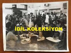 KIBRIS BARIŞ HAREKATI SÜRECİNDE KIBRIS'TAN ÇIKARILAN İNGİLİZ ve DİĞER YABANCI TURİSTLERİN ORİJİNAL AJANS-BASIN FOTOĞRAFI - 20 x 15 cm EBADINDA - (AÇIKLAMAYI OKUYUNUZ) - 1974 - TURİSTLER KAPALI BİR ORTAMDA TOPLUCA YEMEK YERKEN
