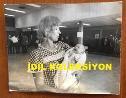 KIBRIS BARIŞ HAREKATI SÜRECİNDE KIBRIS'TAN ÇIKARILAN İNGİLİZ ve DİĞER YABANCI TURİSTLERİN ORİJİNAL BÜYÜK BOY AJANS-BASIN FOTOĞRAFI - 24 x 19 cm EBADINDA - (AÇIKLAMAYI OKUYUNUZ) - 1974 - SAVAŞ SIRASINDA KIBRIS'TA DOĞUM YAPAN BİR İNGİLİZ ANNE ve BEBEĞİ (JENNIFER DUNNET & BETHAN DUNNET)