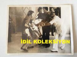 KIBRIS BARIŞ HAREKATI'NIN ORİJİNAL AJANS-BASIN FOTOĞRAFI - 20 x 15 cm EBADINDA - ÇARPIŞMALARDA YARALANAN BİR KİŞİNİN HOTEL NICOSIA İÇİNE GETİRİLİŞİ, 1974