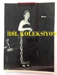 TÜRK HALK MÜZİĞİ SANATÇISI NEZAHAT BAYRAM'IN ORİJİNAL BÜYÜK BOY FOTOĞRAFI - 24 x 17 cm EBADINDA - NEZAHAT BAYRAM SİYAH ŞIK ELBİSESİYLE SAHNEDE TÜRKÜ OKURKEN ÇEKİLMİŞ BİR KARE