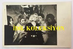TÜRK HALK MÜZİĞİ SANATÇISI NEZAHAT BAYRAM'IN ORİJİNAL FOTOĞRAFI - 18 x 12 cm EBADINDA - NEZAHAT BAYRAM BİR FİLM SAHNESİNDE HÜZÜNLÜ DURURKEN ÇEKİLMİŞ BİR KARE