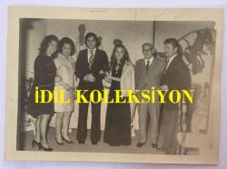 TÜRK HALK MÜZİĞİ SANATÇISI NEZAHAT BAYRAM'IN ORİJİNAL FOTOĞRAFI - 18 x 13 cm EBADINDA - NEZAHAT BAYRAM, KIZI SUNA, NİŞANLISI ARİF ve MUZAFFER AKGÜN TOPLUCA HATIRA POZU VERİRKEN ÇEKİLMİŞ BİR KARE