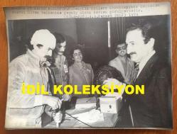 TÜRKİYE CUMHURİYETİ ESKİ BAŞBAKANI BÜLENT ECEVİT'İN BÜYÜK BOY ORİJİNAL AJANS-BASIN FOTOĞRAFI - 23 x 17 cm EBADINDA - BAŞBAKAN BÜLENT ECEVİT, CHP'NİN GENÇLİK KOLLARI KURULTAYINDA BAŞI SARILI OLAN DİVAN BAŞKANINA GEÇMİŞ OLSUN DERKEN ÇEKİLMİŞ BİR KARE, 1979