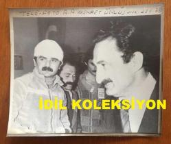 TÜRKİYE CUMHURİYETİ ESKİ BAŞBAKANI BÜLENT ECEVİT'İN BÜYÜK BOY ORİJİNAL AJANS-BASIN FOTOĞRAFI - 21 x 17 cm EBADINDA - BAŞBAKAN BÜLENT ECEVİT, CHP'NİN GENÇLİK KOLLARI KURULTAYINDA BAŞI SARILI OLAN DİVAN BAŞKANIYLA YAN YANAYKEN ÇEKİLMİŞ BİR KARE, 1979 - MEHMET ÜNLÜ