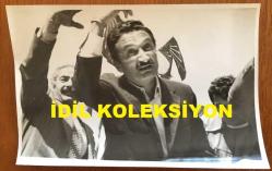 TÜRKİYE CUMHURİYETİ ESKİ BAŞBAKANI BÜLENT ECEVİT'İN ORİJİNAL FOTOĞRAFI - 18 x 12 cm EBADINDA - BÜLENT ECEVİT''İN 22 MAYIS 1977 OLAYLI KARS MİTİNGİNDE BULUNDUĞU YERDEN OLAYLARA MÜDAHALE ETMEYE ÇALIŞIRKEN ÇEKİLMİŞ BİR KARE