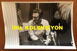 TÜRKİYE CUMHURİYETİ ESKİ BAŞBAKANI BÜLENT ECEVİT'İN ORİJİNAL FOTOĞRAFI - 18 x 12 cm EBADINDA - BÜLENT ECEVİT''İN 22 MAYIS 1977 OLAYLI KARS MİTİNGİNDE AJANDASIYLA YERE OTURUP ENDİŞELİ BİR ŞEKİLDE DÜŞÜNDÜĞÜ ANLARDA ÇEKİLMİŞ BİR KARE