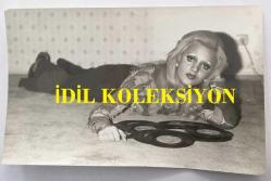 OYA GERMAN'IN ORİJİNAL FOTOĞRAFI 18 x 11 cm EBADINDA - OYA GERMAN YERE UZANIP 45'LİK PLAKLARIYLA POZ VERİRKEN ÇEKİLMİŞ BİR KARE