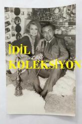 SEVTAP ÇETİNKALE'NİN ORİJİNAL FOTOĞRAFI - 14 x 9 cm EBADINDA - SEVTAP ÇETİNKALE, SEVGİLİSİ BÜLENT ORAL'LA BİRLİKTE HEDİYELİK EŞYA DÜKKANINDA POZ VERİRKEN ÇEKİLMİŞ BİR KARE. FOTO AR. KONYA