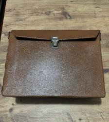 Vintage Kahverengi Evrak Çantası Eski dönemden kalma kahverengi suni deri evrak çantası. Metal kilidi çalışır durumda, genel durumu iyi. Yaklaşık 1960–1980 yılları arası üretimdir. Koleksiyon, dekor veya günlük kullanım için uygundur. Taşıma kayışı yok Ölçüleri Uzunluk 34 cm En 12,5cm Yükseklik 24 cm