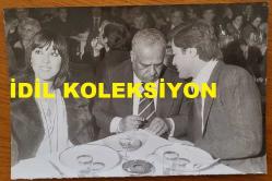 NEBAHAT ÇEHRE'NİN ORİJİNAL FOTOĞRAFI - 18 x 12 cm EBADINDA - NEBAHAT ÇEHRE, BASKETBOLCU EŞİ YAVUZ DEMİR'LE BİR MEKANDA YEMEK YERKEN ÇEKİLMİŞ BİR KARE. 1970'LER