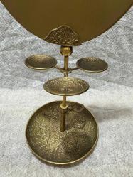 Hint Yapımı Pirinç Aynalı Takı Standı Hint el işçiliği pirinçten üretilmiş, üstü aynalı dekoratif takı standı. Üç küçük takı tabağı ve geniş taban haznesiyle kullanışlı ve vitrinlik bir parçadır. Temiz, sorunsuz durumdadır. Malzeme: Pirinç Menşei: Hindistan Dönem: 20. yy ortaları