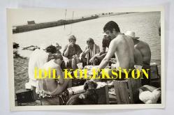 YEŞİLÇAM OYUNCUSU TANJU KOREL'İN ORİJİNAL 10'LU FOTOĞRAF SETİ - 14 x 9 cm EBADINDA - TANJU KOREL, BİR KIYIDA PİKNİK YAPTIĞI TURİSTLERLE BİRLİKTE YEMEK YERKEN ve BİR KOÇA İÇKİ İÇİRİRKEN ÇEKİLMİŞ 10 FARKLI KARE