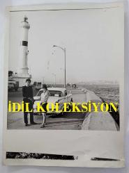 YEŞİLÇAM OYUNCUSU TANJU KOREL'İN ORİJİNAL BÜYÜK BOY FOTOĞRAFI - 24 x 18 cm EBADINDA - TANJU KOREL, ÜSKÜDAR SAHİLİNDE KIZ KULESİ YÖNÜNE YÜRÜRKEN FENERİN YANINDA POZ VERİRKEN ÇEKİLMİŞ BİR KARE