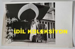 TÜRK HEKİM ve SİYASETÇİ, 1968-1973 İSTANBUL BELEDİYE BAŞKANI DOKTOR FAHRİ ATABEY'İN ORİJİNAL FOTOĞRAFI - 18 x 12 cm EBADINDA - DR. FAHRİ ATABEY, RESMİ BİR KUTLAMADA KÜRSÜYE ÇIKIP BÜYÜK TÜRK BAYRAĞI ÖNÜNDE KONUŞMA YAPARKEN ÇEKİLMİŞ BİR KARE