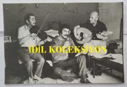 YEŞİLÇAM OYUNCUSU TANJU KOREL'İN ORİJİNAL AJANS-BASIN FOTOĞRAFI (KAĞIT BASKI) - 18 x 12 cm EBADINDA - TANJU KOREL, KEMAN ve UT EŞLİĞİNDE ŞARKI OKURKEN ÇEKİLMİŞ BİR KARE